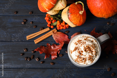 Cup with tasty pumpkin spice latte on blue wooden table, flat lay