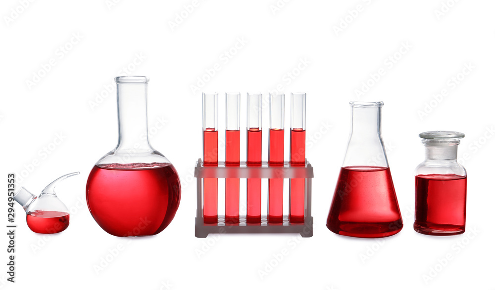 Set of laboratory glassware with red liquid on white background