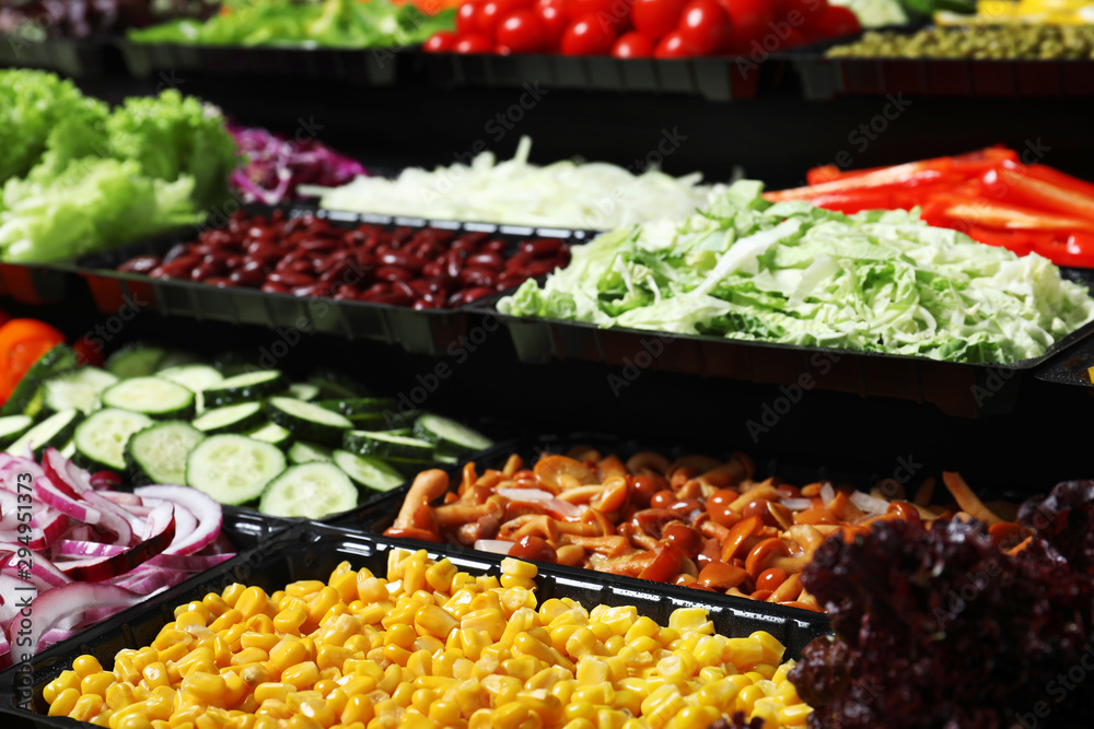 Salad bar with different fresh ingredients as background