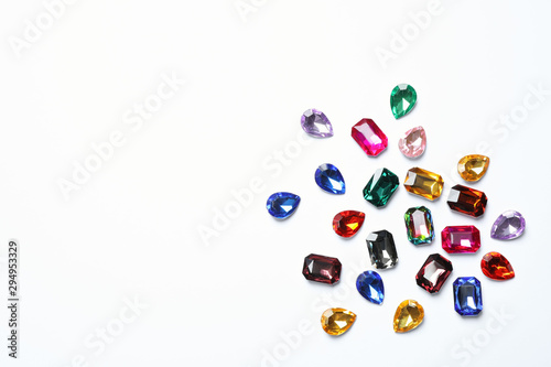 Different beautiful gemstones on white background, top view