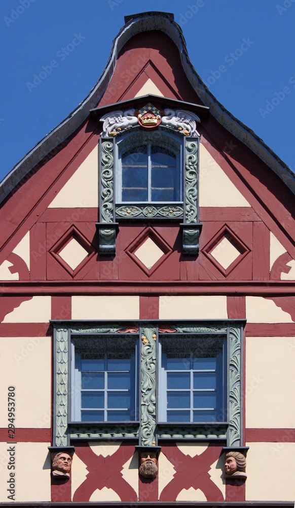 A half-timbered gable with wooden window frames at a traditional house facade in Germany