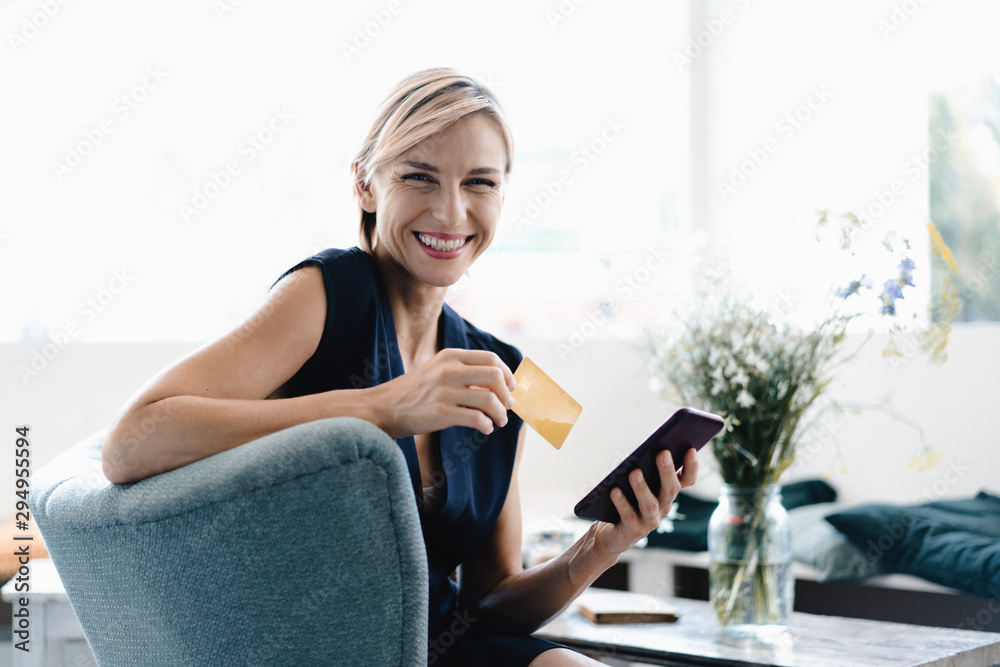 Businesswoman making online payment, using smartphone and credit card in a coffee shop Businesswoman making online payment, using smartphone and credit card in a coffee shop
