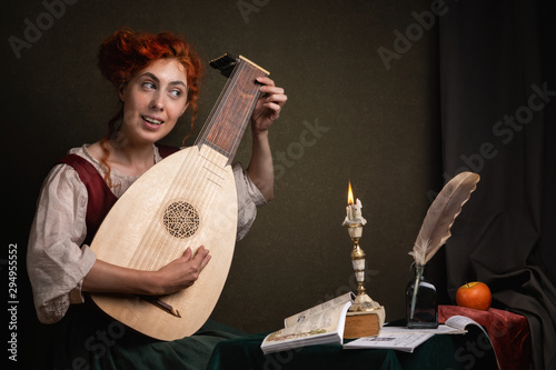 Tableau sur toile Red-haired girl in a historical suit plays the lute