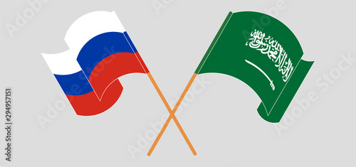 Crossed and waving flags of Kingdom of Saudi Arabia and Russia