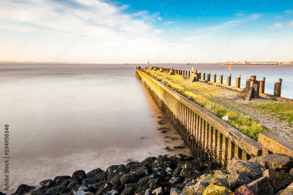 Fototapeta premium Sunset in England, rocky Portishead coast line in long exposure capture.