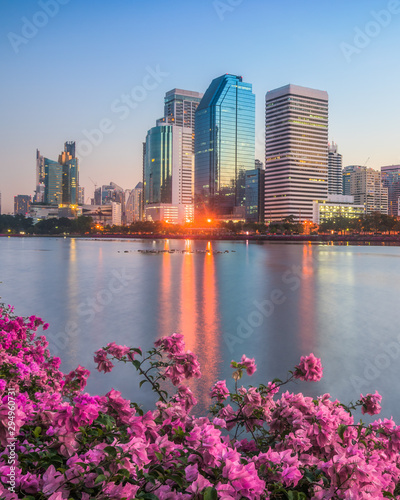 Lake with Purple Flowers in City Park under Skyscrapers at Sunrise. Benjakiti Park in Bangkok, Thailand photo