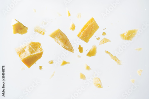 Parmesan cheese flying in different directions with crumbs on a white background with space for the text.