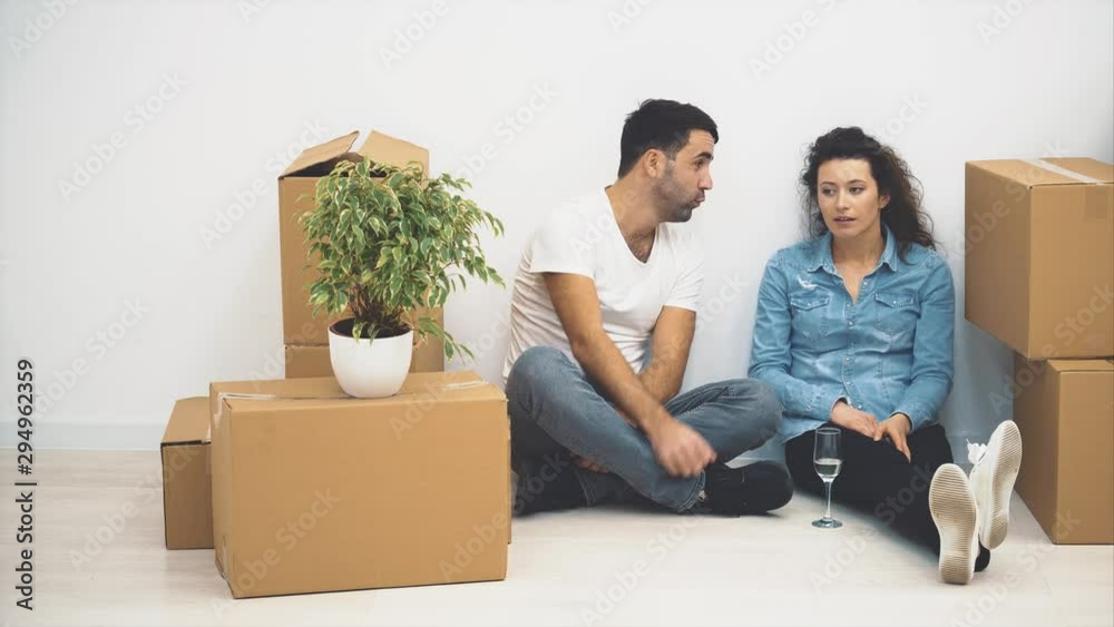 Young couple are talking while sitting on the floor. 4K. Young couple are talking while sitting on the floor. 4K.