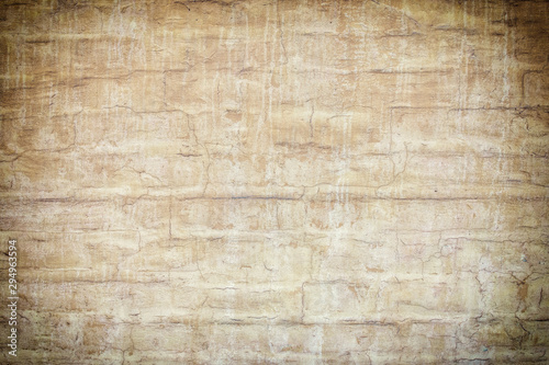 Brick wall painted in light brown paint. Old coating in spots and smudges, photo with vignette. Empty background for layouts and sites.