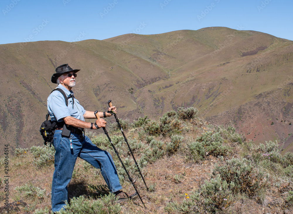 Senior Man Hiking with hiking poles and looking Up