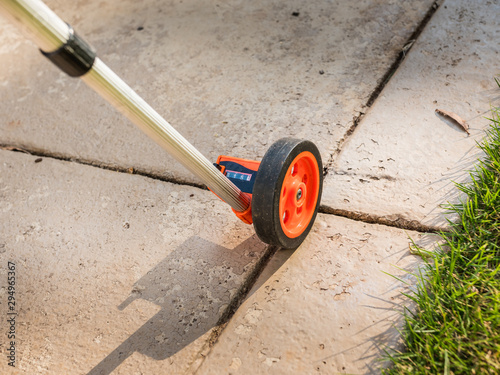 Measuring wheel tool for calculating distance. Outdoor surveying measurement tool with rolling odometer. photo