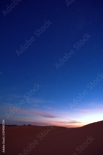 Nightfall on the desert. The first stars can be seen in the deep blue sky.
