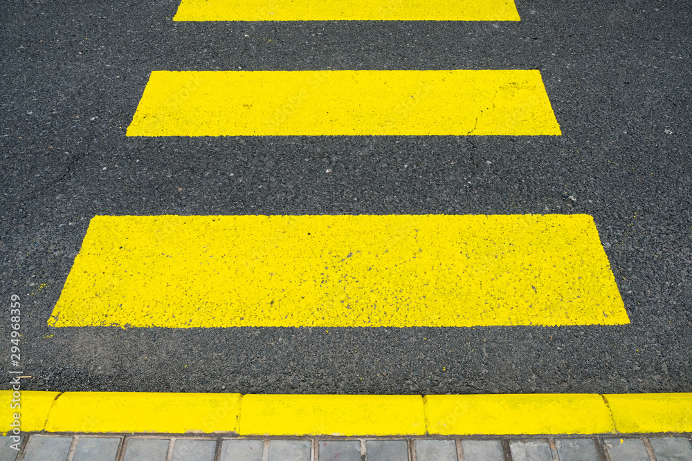 Fototapeta premium Yellow zebra crossing bands painted on the road.