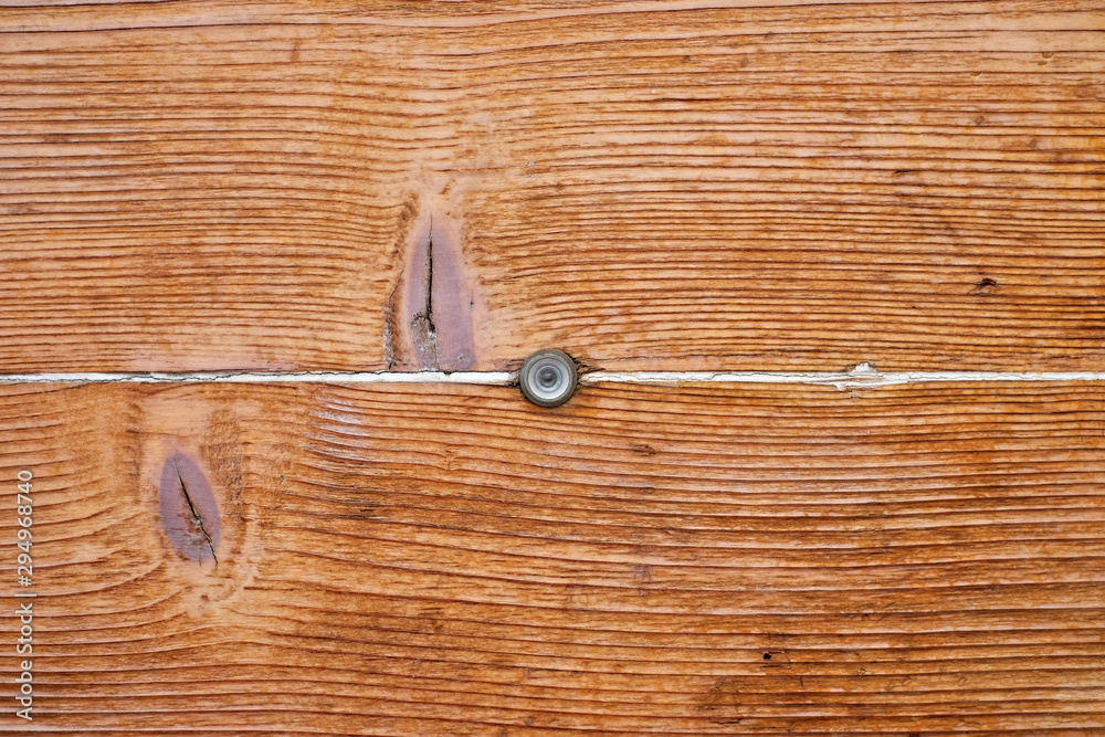 Perfect tiny peeping hole in a timber door surface. Perfect tiny peeping hole in a timber door surface.