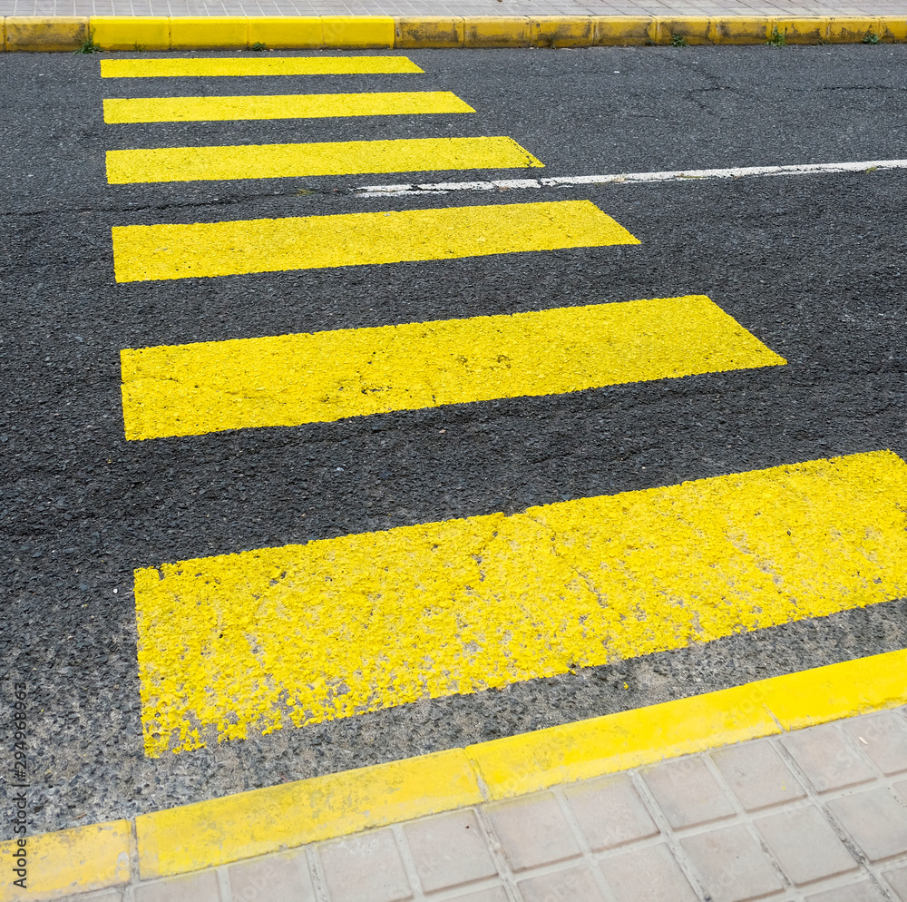 Fototapeta premium Yellow zebra crossing bands in diagonal perspective.