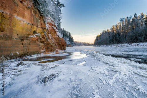 Ice formations in river during cold winter at sunrise. © valdisskudre