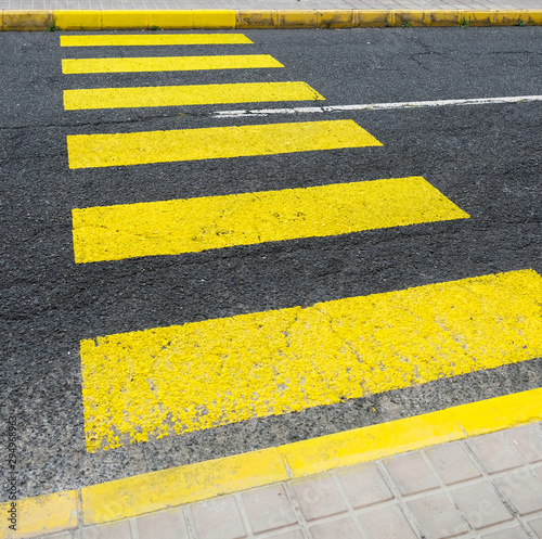 Yellow zebra crossing bands in diagonal perspective. © Daguimagery