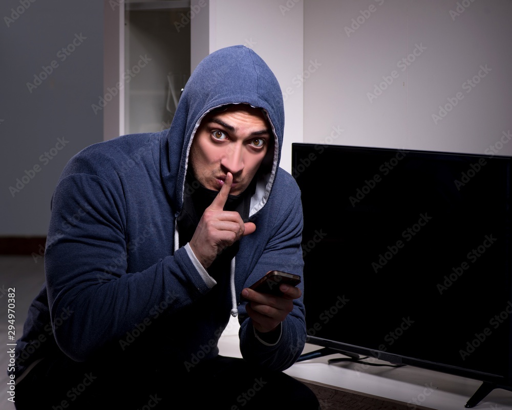 Burglar thief stealing tv from apartment house Burglar thief stealing tv from apartment house