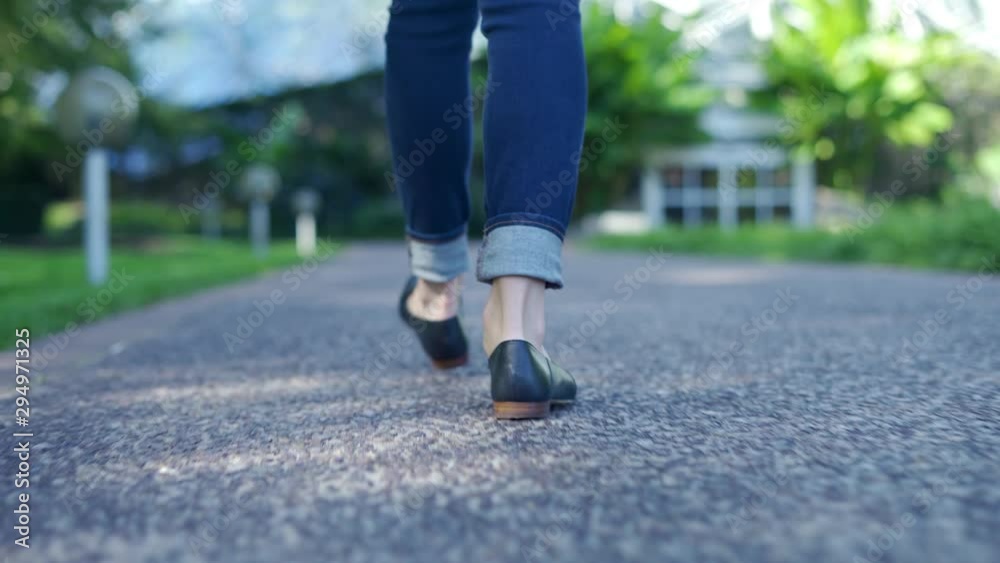 Low angle shot of Young woman walking outside in city park during the day. Focused only on the feet and shoes with shallow depth of field Low angle shot of Young woman walking outside in city park during the day. Focused only on the feet and shoes with shallow depth of field