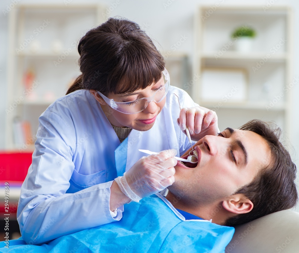 Woman dentist doctor with male patient in hospital Woman dentist doctor with male patient in hospital