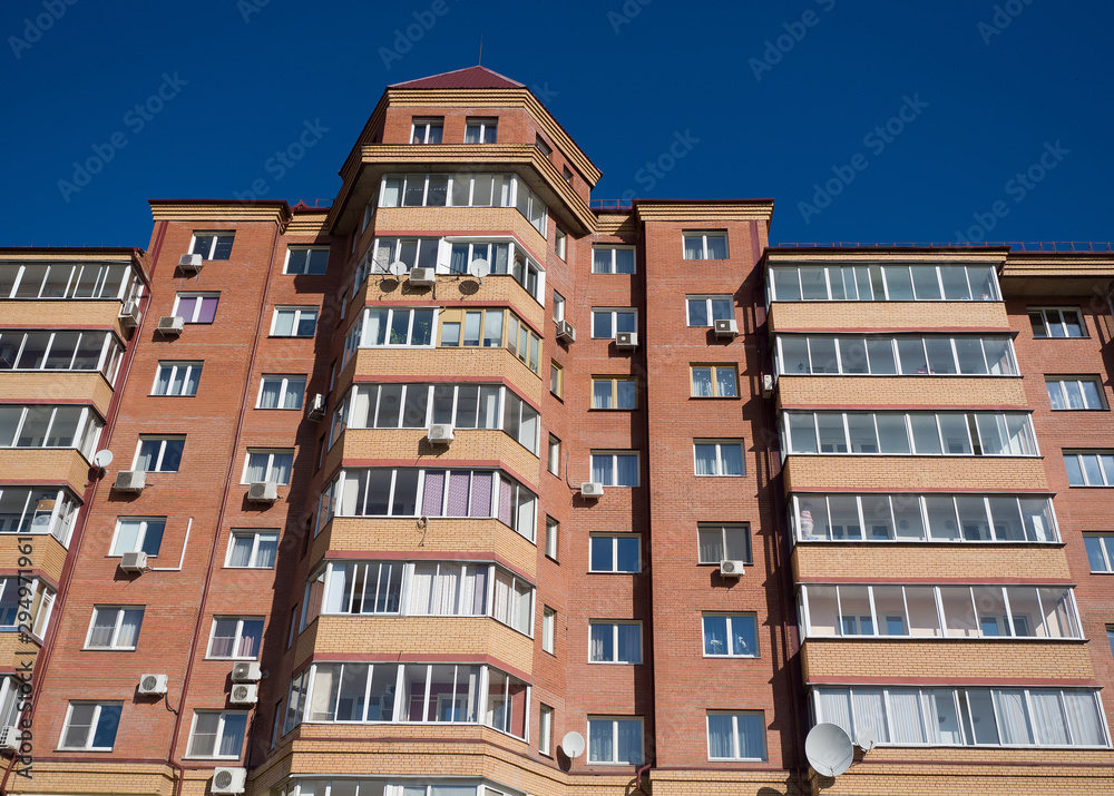 Red brick wall view of a residential building. Theme of modern geometric architecture and urbanization