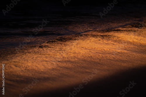 Orange sunset landscape with sea and beach sand. Sun reflection in foamy sea. Cinematographic image. Romantic evening seascape with sunset. Exotic nature landscape
