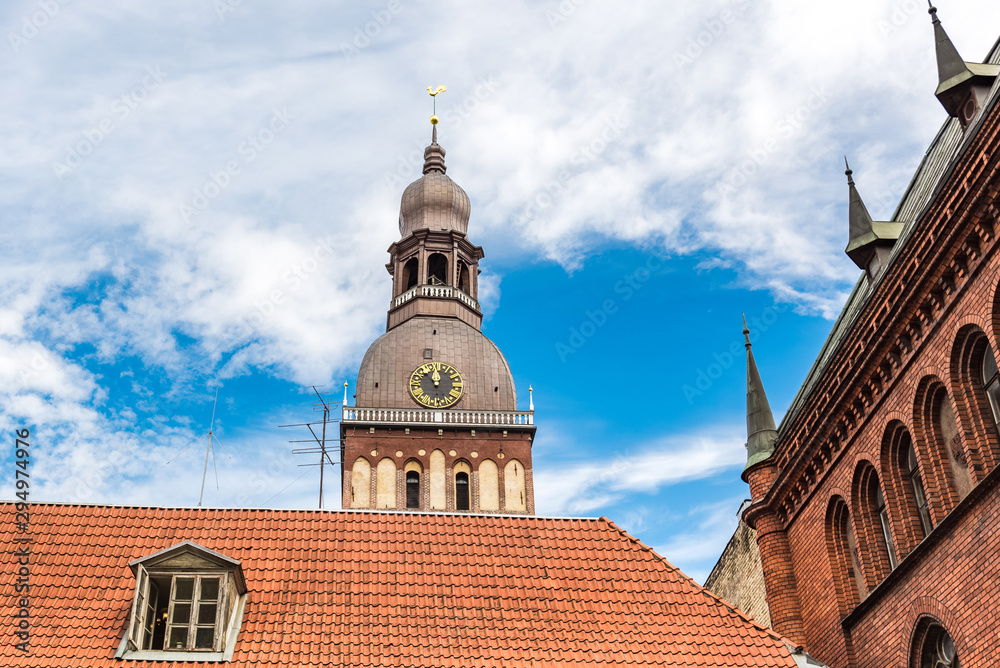 Narrow medieval street in the old Riga city and view St. Peter's Church.