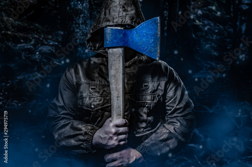 Murderer with an axe in dark woods. photo