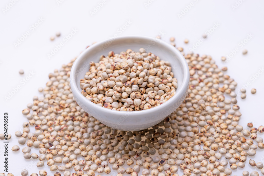 Uncooked raw Sorghum (also known as sorgo) in a white bowl, isolated on white background Uncooked raw Sorghum (also known as sorgo) in a white bowl, isolated on white background