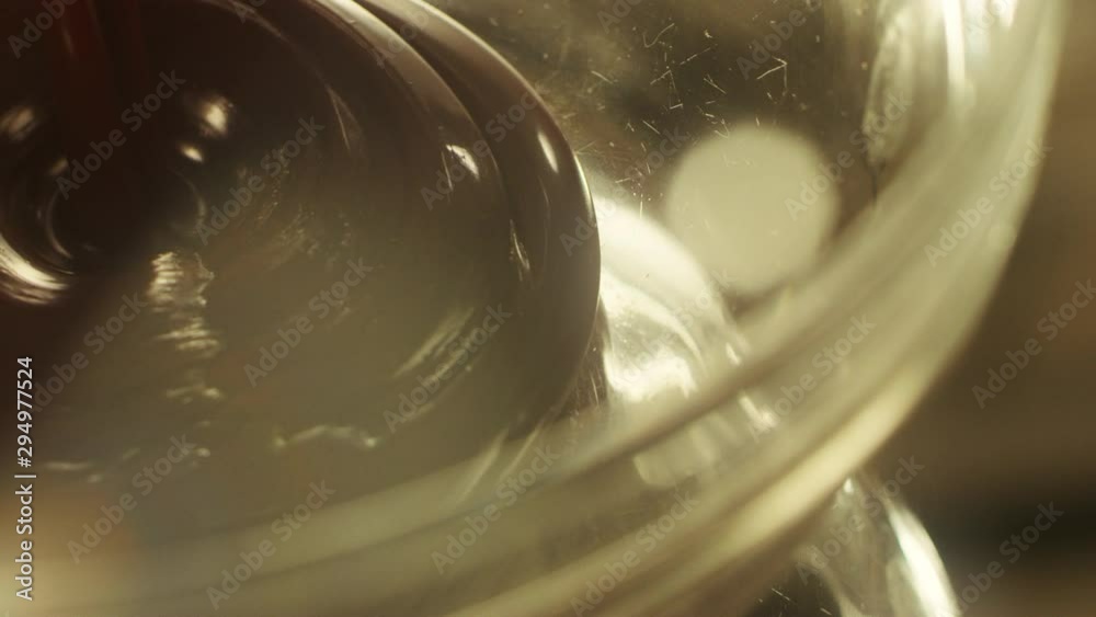 Liquid drops of hot black chocolate dripping in glass bowl. Chocolate syrup Liquid drops of hot black chocolate dripping in glass bowl. Chocolate syrup