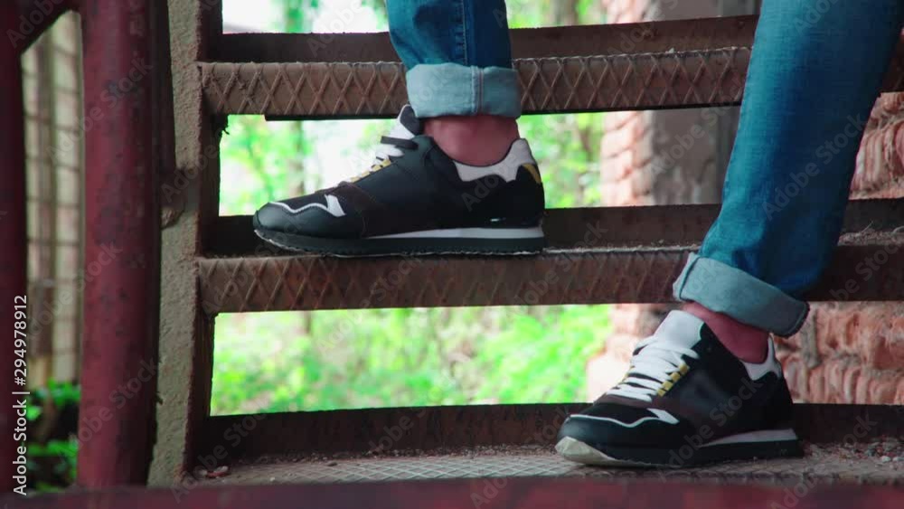 Snickers Person Long shot of person snickers on iron stairs 4K. Long shot dolly slide ...