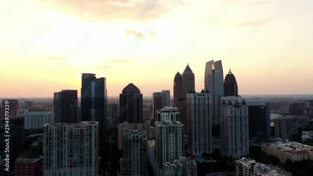 4K Ariel Drone Shot Passing Over Beautiful Skyline Buildings In Charlotte, North Carolina. USA. Golden Sun Shining Through Gaps Of Buildings. Area Covered With Trees. Golden Yellow Sunset. 4K Ariel Drone Shot Passing Over Beautiful Skyline Buildings In Charlotte, North Carolina. USA. Golden Sun Shining Through Gaps Of Buildings. Area Covered With Trees. Golden Yellow Sunset.