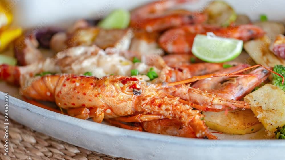 Grilled seafood with lobster, shrimp, squid and fish, accompanied by various vegetables. Grilled seafood with lobster, shrimp, squid and fish, accompanied by various vegetables.