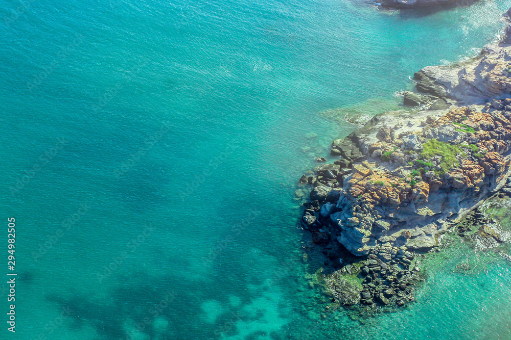 overhead tropical beach coastline with rocks