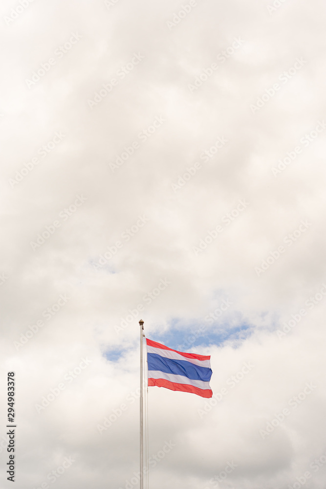 Flag of Thailand on on pole with white clouds and blue sky. Copy space wallpaper.