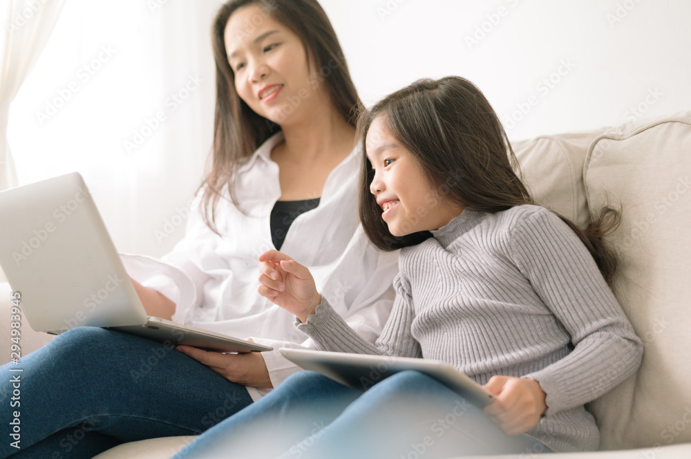 happy mother and daughter with laptop and tablet pc happy mother and daughter with laptop and tablet pc