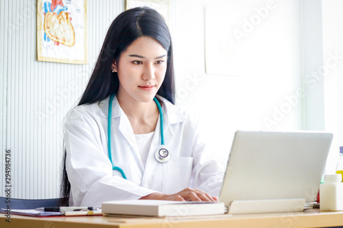 The female doctor sat and looked at the treatment information in the examination room. Patient care concepts