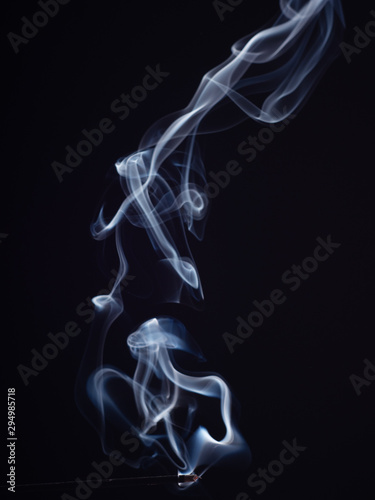 Swirl of white smoke isolated on black background, close up view. Abstract pattern of white smoke, brush effect. Burning incense, abstract background. Sweet smell for meditation and relaxation