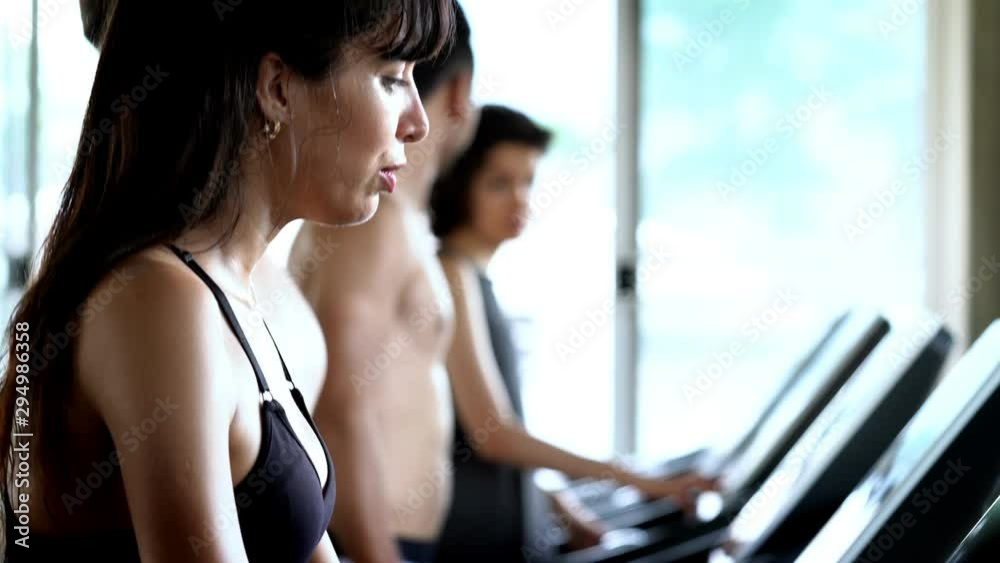 4K Group of athletic sport man and woman teamwork in sportswear cooling down after do cardio workout running on treadmill in training class at fitness gym and talking together for healthy lifestyle. 4K Group of athletic sport man and woman teamwork in sportswear cooling down after do cardio workout running on treadmill in training class at fitness gym and talking together for healthy lifestyle.