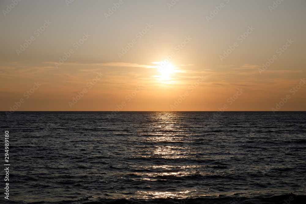 Dark sea surface with waves and sun reflection
