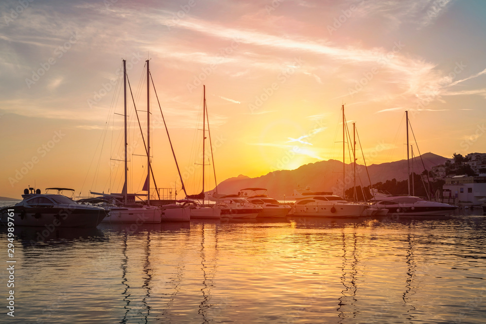 Sunset in Baska Voda town with Adriatic Sea and boats, Croatia