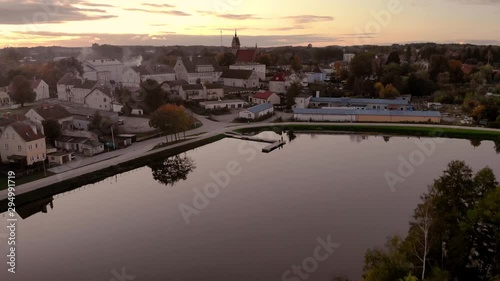 Aerial footage on the pond in the middle of the city, historic town in Poland, recreational path around the lake in the city, ancient buildings of the city, beautiful sunset in Warmia and Mazury photo