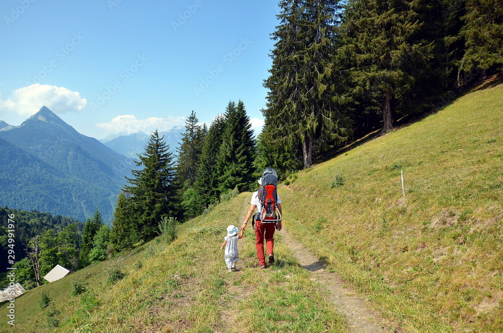 Daughter and father hiking together in French Alps in summer, France Daughter and father hiking together in French Alps in summer, France