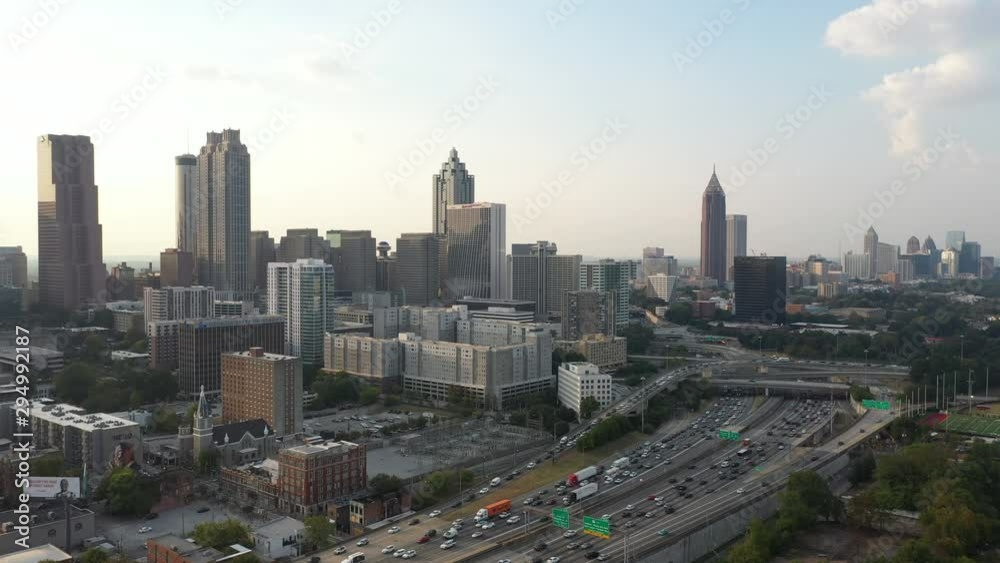 4K Ariel Drone Shot Over Skyline Buildings In Atlanta, Georgia. USA. Pretty Tall Skyline Over Busy Highway Road With Cars Driving Through. Important Tall Buildings, Blue Sky In America 4K Ariel Drone Shot Over Skyline Buildings In Atlanta, Georgia. USA. Pretty Tall Skyline Over Busy Highway Road With Cars Driving Through. Important Tall Buildings, Blue Sky In America