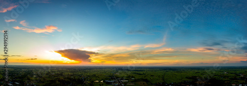Panorama Top view Aerial photo from flying drone over village in Thailand.Top view beautiful Sunset.Sunrise with cloud over rice field. © noon@photo