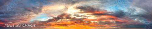 Panorama Sunlight with dramatic sky. Cumulus sunset clouds with sun setting down on dark background.Vivid orange cloud sky.