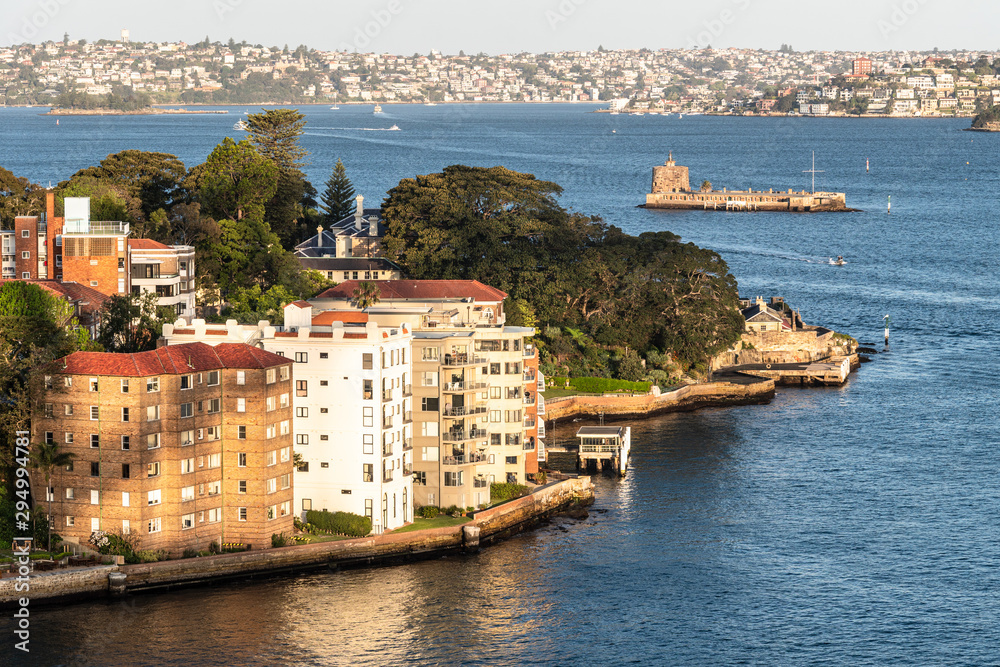 Luxury apartment buildings in the wealthy Kirribilli district by the Sydney bay in Sydney with the Denison fort in the background in Australia largest city.