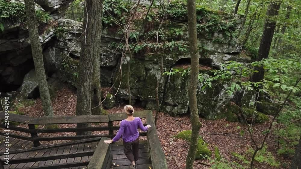 Aerial camera follows a woman walking through Beartown State Park in Hillsboro, West Virginia. Aerial camera follows a woman walking through Beartown State Park in Hillsboro, West Virginia.