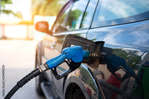 Fuel oil gasoline dispenser at petrol filling station.Holding fuel nozzle to refuel gasoline for car.