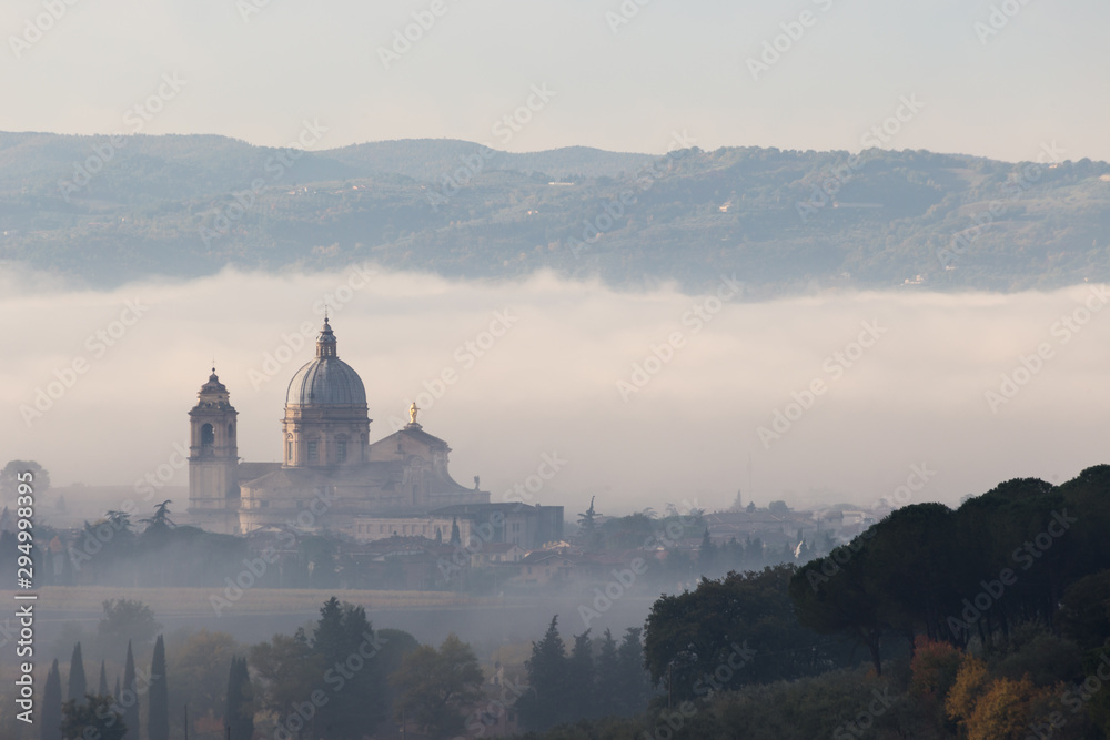 Obraz premium Surreal view of Santa Maria degli Angeli papal church (Assisi) almost completely hidden by fog